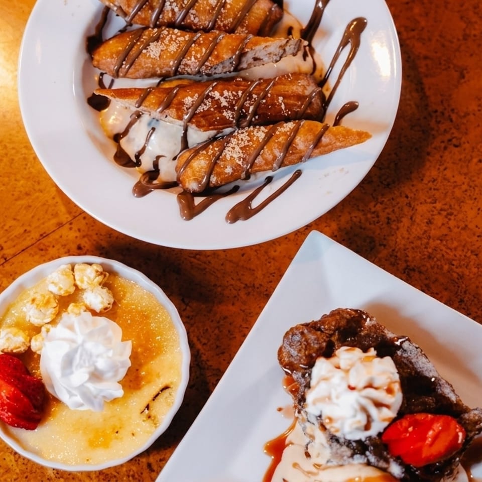 Three dessert plates featuring churros, creme brulee with popcorn, and a waffle with ice cream.